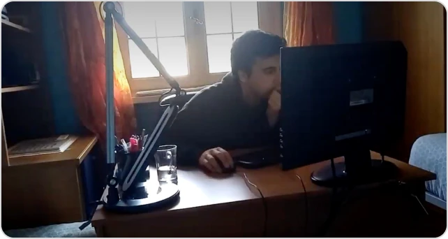 Andrei di notte al computer, illuminato dal monitor.