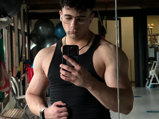 Andrei in palestra, col telefono in mano.